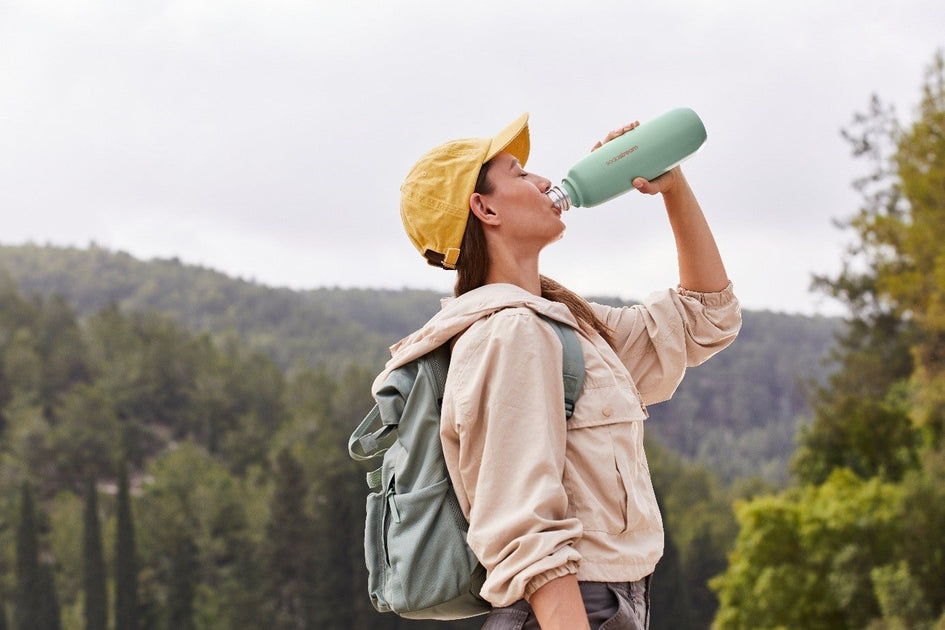Kobieta pijąca wodę gazowaną z butelki SodaStream Fizz&Go.