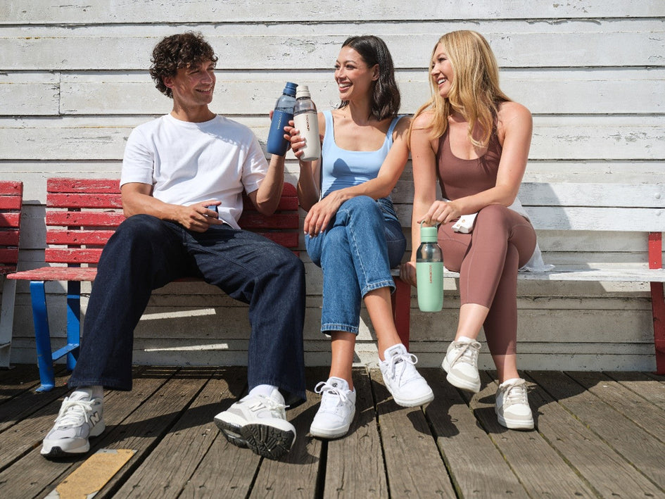 Młodzi ludzie na festiwalu piją wodę gazowaną z butelek SodaStream.